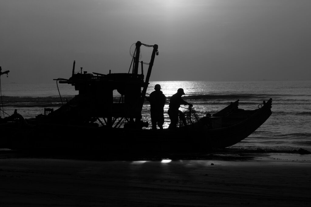 the sun rises as the fishermen check their nets in Thanh Hoa, Vietnam